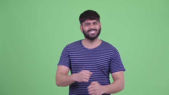 Happy Young Overweight Bearded Indian Man Talking and Looking Excited