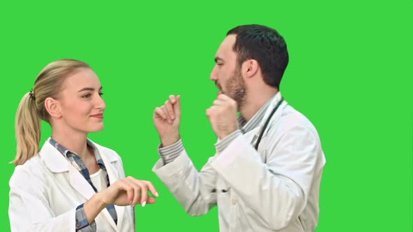 Smiling Young Woman and Man in Lab Coat Making Funny Dance on a Green Screen, Chroma Key