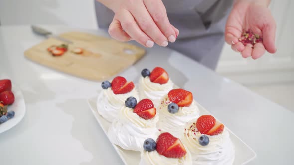 Woman Cook Decorates Cakes Anna Pavlova with Dried and Fresh Berries