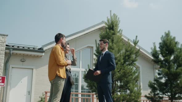 House Buyer Taking Keys From Realtor Shaking Hands Hugging Woman Outdoors