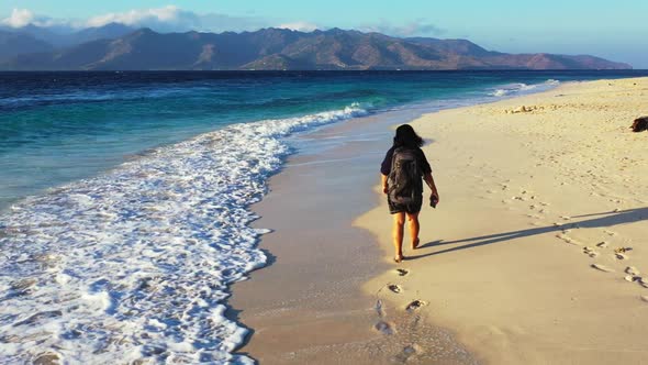 Single female sunbathing on marine coastline beach lifestyle by turquoise sea and white sandy backgr