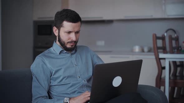 Man Using Modern Laptop and Working at Home