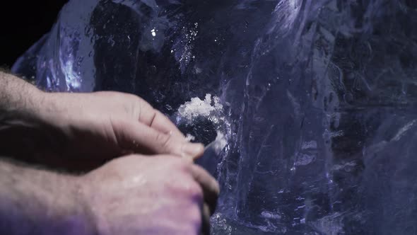 Close Up View of a Man Carving Out a Sculpture of a Lion Out of Ice