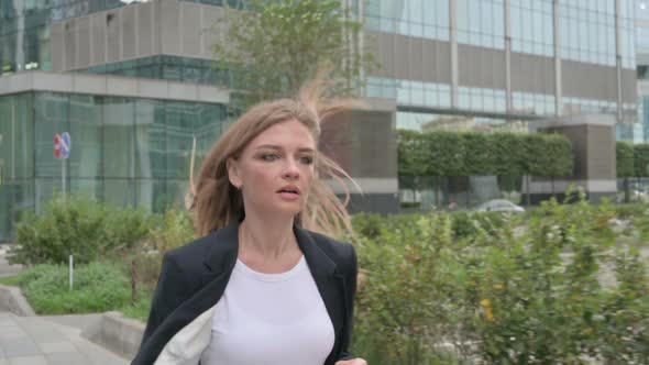 Young Businesswoman Running in Street in Slow Motion Front Pose