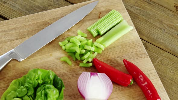 Vegetables and kitchen knife on chopping board