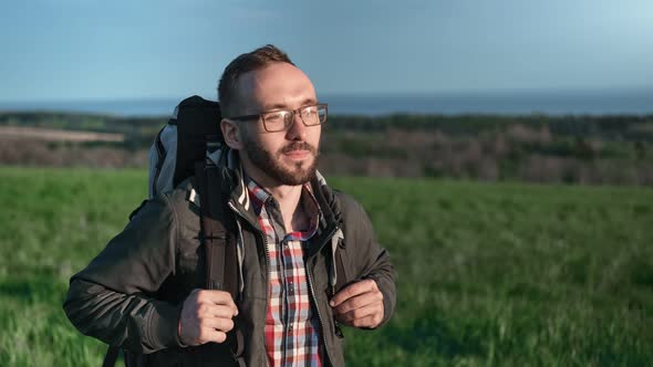 Smiling Bearded Guy with Backpack Going at Nature Landscape