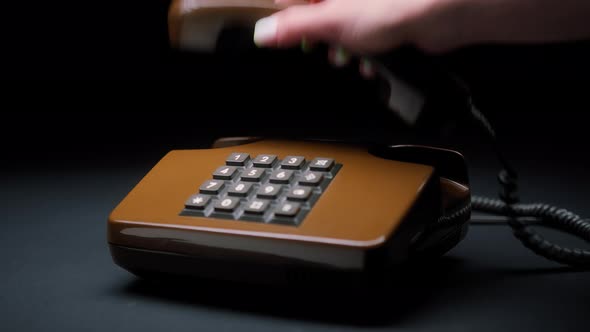 Female Hand Holding Old and Retro Brown Telephone Headset Isolated on Black Background Woman Hands