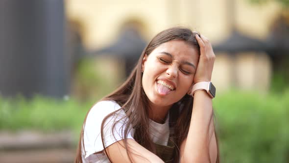 Beautiful Woman Sitting on a Bench and Smiling at the Camera