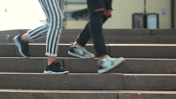 Close Up Legs of Young Couple Walking Down Stairs