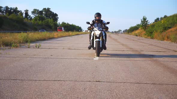 Man in Helmet Driving Powerful Sport Motorbike at Highway. Motorcyclist Speeding on Motorcycle Along alt