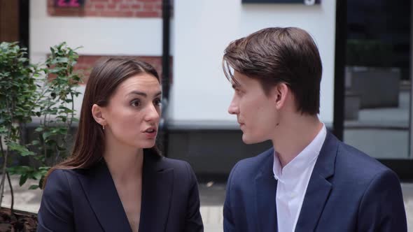 a young couple sit on a bench and communicate