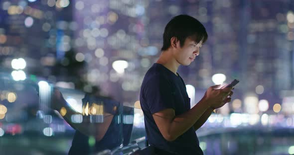 Man use of cellphone in city at night