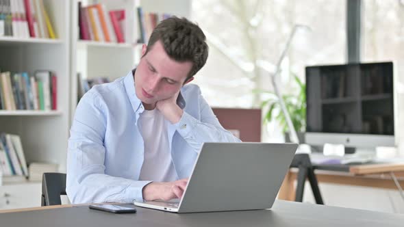 Young Man with Neck Pain Working on Laptop