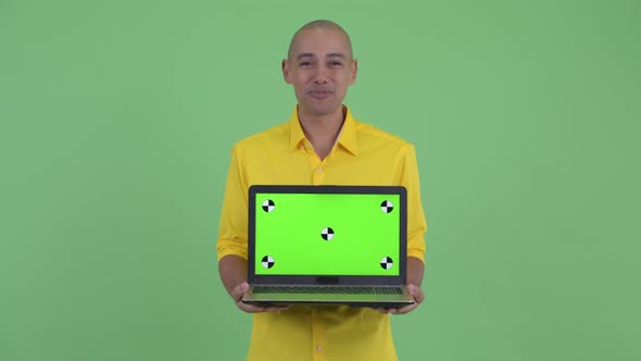 Happy Handsome Bald Businessman Talking While Showing Laptop