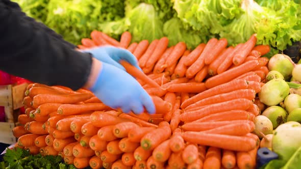 The seller puts the carrots on the counter.