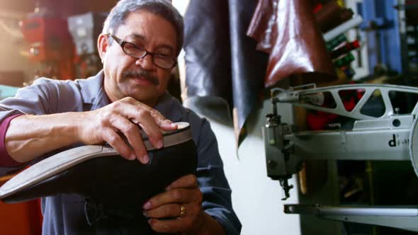 Shoemaker examining a shoe