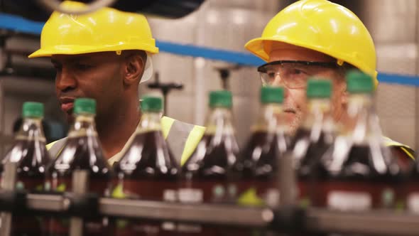 Workers checking bottles on production line