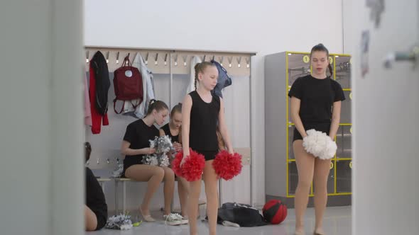 Schoolgirls Waiting for Cheerleading Practice in Locker Room