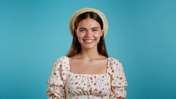 Excited Gorgeous Woman in Floral Dress and Hat Can't Believe She Won Lottery Prize, Shaking Head