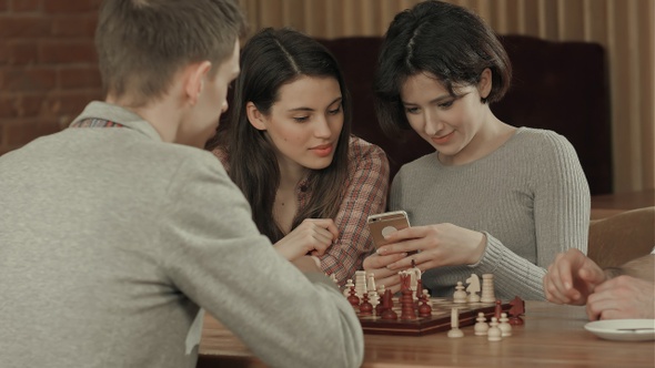 Girl taking photo of playing chess