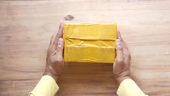 Hand Hold a Delivery Package on Table