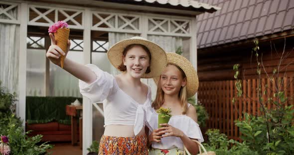 Rural Teenager Girls in Straw Hat in Countryside with Wildflowers on Wooden House Background Showing