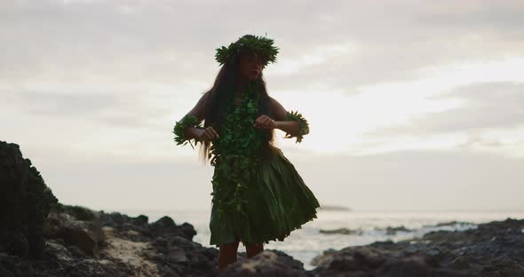 Woman performing traditional Hawaiian hula by the ocean alt