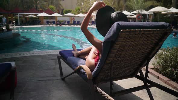 Girl on a Lounger By the Pool