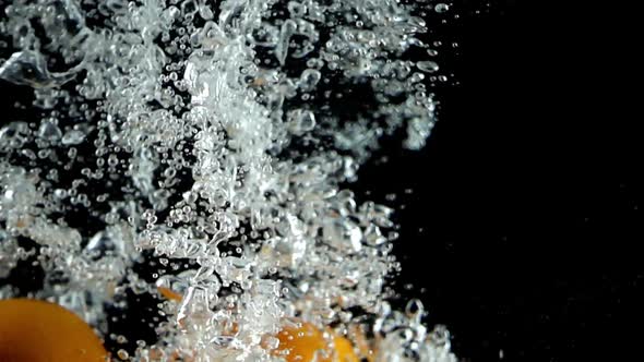 6 Tangerines Splashed into Water in Ultra Slow Motion - Black Background