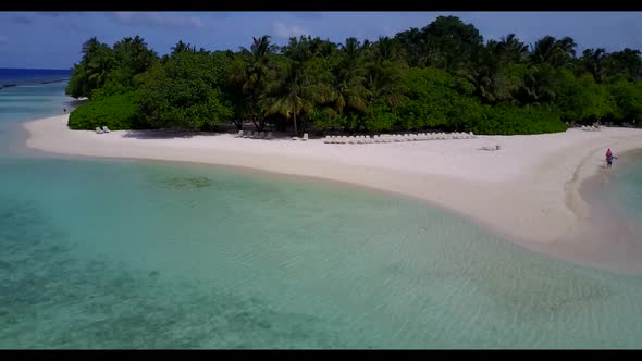 Aerial drone shot tourism of paradise coastline beach break by clear ocean with white sand backgroun
