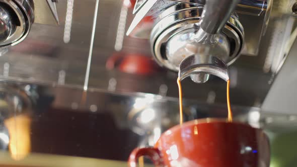 Extraction of Fresh Espresso Coffee in Streams Pouring Into a Brown Ceramic Mug From a Double Holder