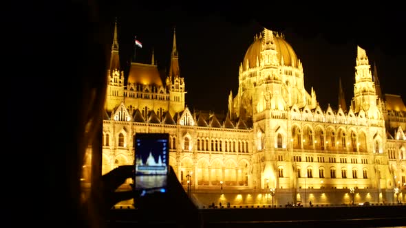 Girl photographing Budapest night parliament