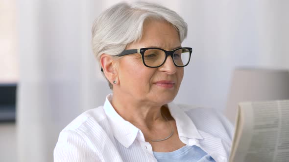 Portrait of Senior Woman Reading Newspaper at Home 