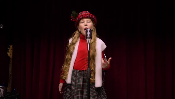 Young Girl in Christmas Concept Sings Song Front Retro Microphone on Dark Stage