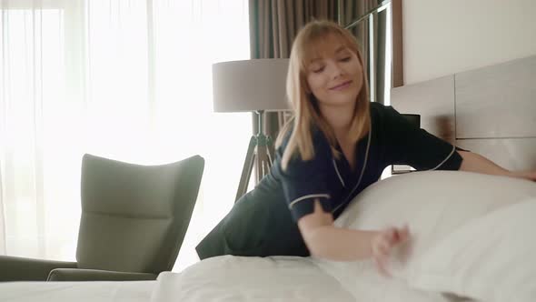 Housekeeper making the bed in hotel room