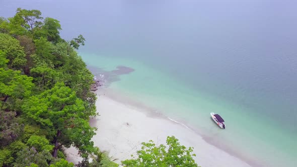 Beautiful horizontal to eagle eye drone shot of a small boat in still water with nature and sea surr