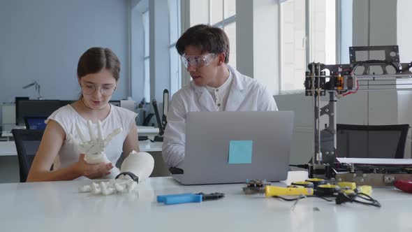 Girl in Glasses Examines 3D Printed Hands in Class
