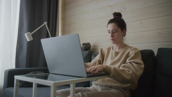 Concentrated woman works on laptop