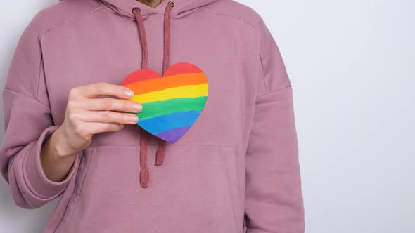 Woman or Girl in Purple Hoodie Holding Heat Painted in Colors of Gay Pride Flag Colorful Symbol of