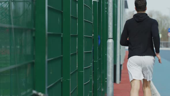 Man running along a fence