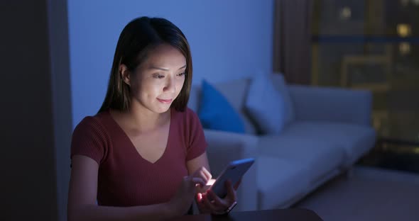 Woman work on cellphone at night 