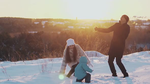 Man Woman and Child in Winter Clothes Throw White Snow