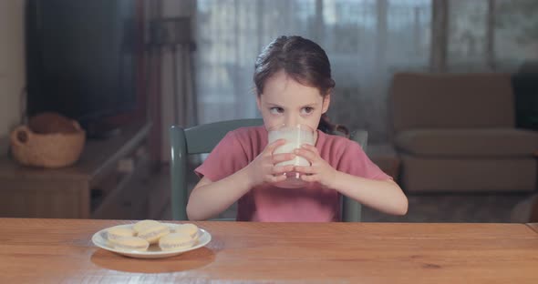 Little cute girl drinking a glass of milk