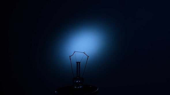 Electric Bulb Lamp with a Burning Spiral on a Black Background