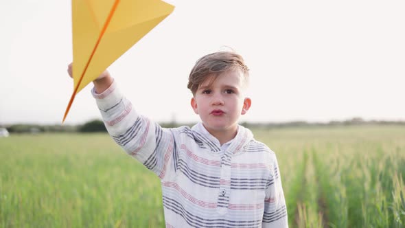 Happy child having fun playing with paper airplane toy outdoor