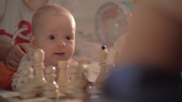 Cute Baby Girl Watching Chess Game