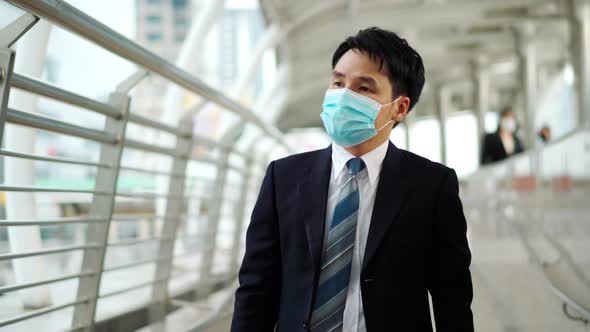 business man walking and wearing medical mask during coronavirus (covid-19) pandemic in the city