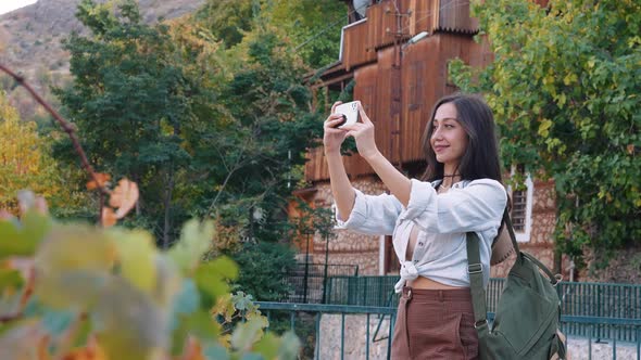 Woman Taking Video of Scene on the Street