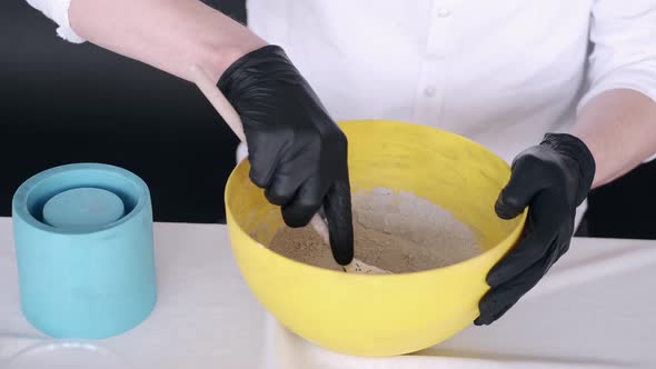 Closeup of Hands Preparing Mixture for Modling in Yellow Bowl