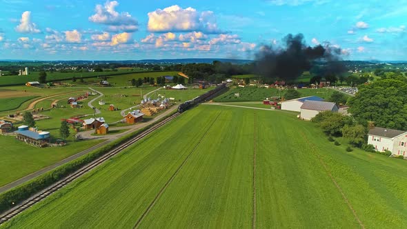 Aerial View of Amish Farm lands With a Single Rail Road Track and a Steam Passenger Train